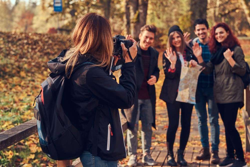 FormatFactorygirl-taking-photo-her-friends-group-young-friends-hiking-through-forest-travel-hiking-adventure-concept.jpg